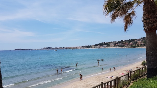 A beach with a wooden fence, people swimming and sunbathing, and a clear sky. - BANDOL - Seaside - Beautiful Apartment - all Comfort - Air Conditioning-Wifi... (Bandol)