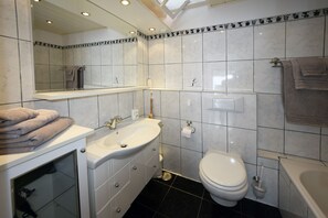 Un bagno con lavandino, WC e vasca da bagno.