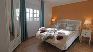A bedroom with a large bed, two bedside tables, a wardrobe, and a window with curtains. - ViVa Tropical (Buzanada, Arona)