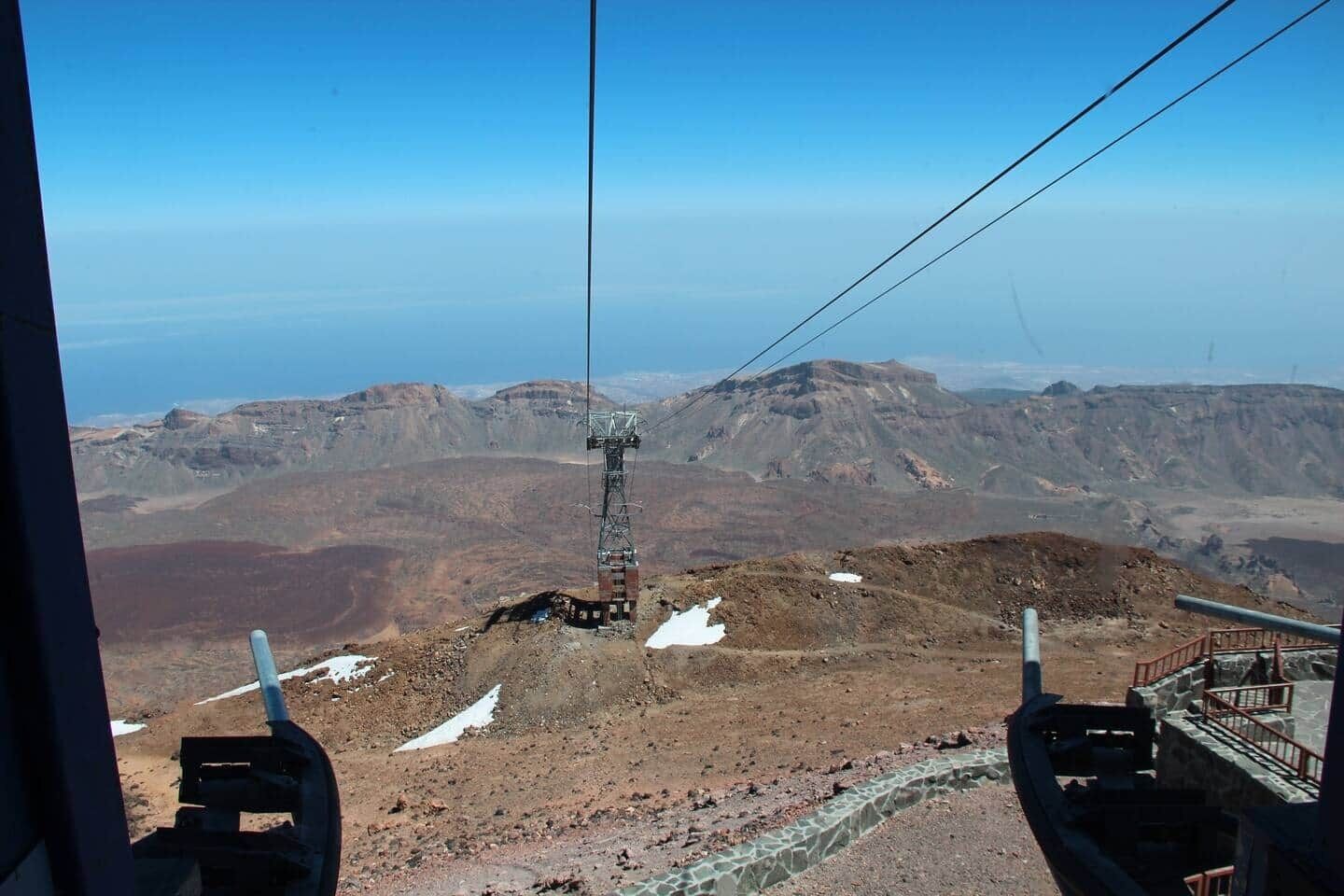 Un sistema de teleférico con un paisaje montañoso al fondo.