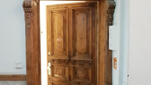 A wooden door with intricate carvings and a small window.