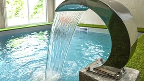 A pool with a curved water feature.
