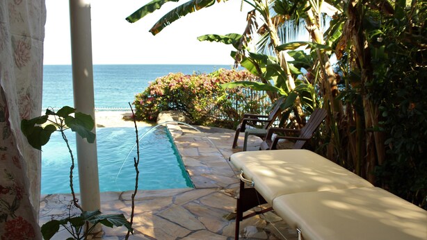 A poolside area with a lounge chair, a small pool, and a view of the ocean. - Birdie's Nest condo #2 with ocean view (Black Rock)