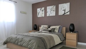 A bedroom with a bed, nightstands, and wall art. - Sun, beach, and great savings –discover amazing discounts on dream destinations! (Cape Coral)