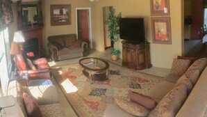A living room with a sofa, armchairs, a coffee table, a television, and a fireplace. - Sleeps 6 in 4 Queen Beds, former farmland, near New Bern, home of Tryon Palace. (New Bern)