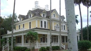 A large, two-story house with a wrap-around porch, multiple windows, and a symmetrical facade. - Sun, beach, and great savings –discover amazing discounts on dream destinations! (Cape Coral)