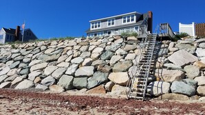 Una escalera de piedra que conduce a una casa con cerca blanca y una bandera.