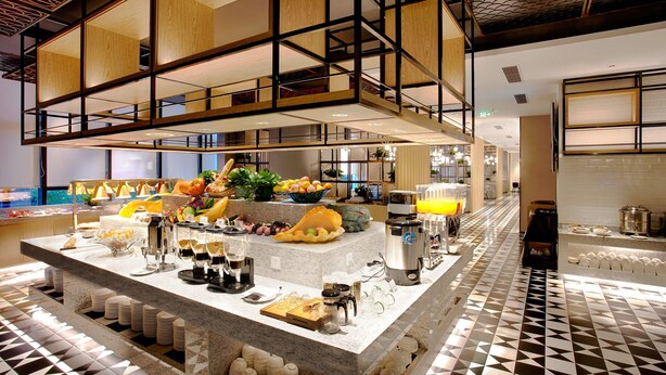 A breakfast buffet with various food items and beverages, a coffee machine, and a tiled floor. - Shenzhen FY Hotel (Shenzhen)