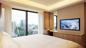 A hotel room with a large bed, a TV on the wall, and a city view. - Shenzhen FY Hotel (Shenzhen)