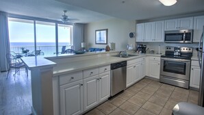 A modern kitchen with white cabinets, stainless steel appliances, and a large island.