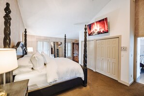 A bedroom with a four-poster bed, a television mounted on the wall, and a door leading to another room. -  ADIRONDACK LUXURY LAKE ESTATE: POOL & HOT TUB! NEWLY RENOVATED! (Remsen)