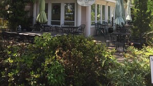 Café Magnolia Bakery con terraza y una galería de regalos de jardinería.