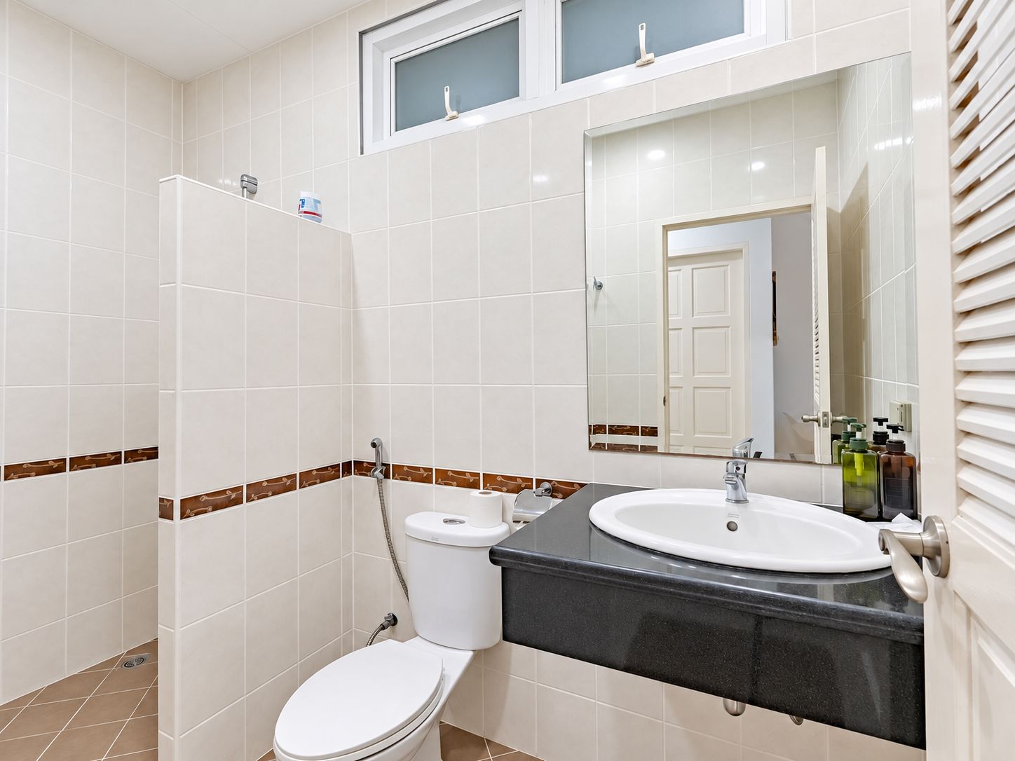 Un baño con inodoro, lavamanos y espejo.