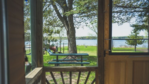 Eine Holzterrasse mit Picknicktisch und einem Spielplatz im Hintergrund.