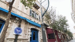 Un bâtiment doté d’un auvent bleu et d’une enseigne sur laquelle on peut lire « Yasas ».