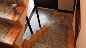 A staircase with granite steps and metal railings leading to a door with a window. - OYAJI Guesthouse (Tainan)