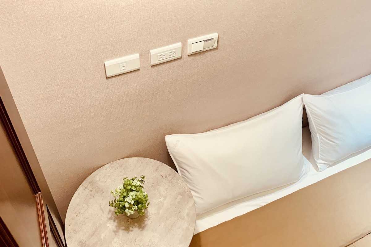 Una habitación moderna con una mesa redonda, un sofá blanco y una lámpara colgante.