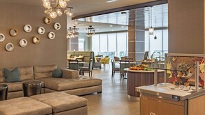 A modern hotel lobby with a seating area, a Chobani counter, and large windows providing natural light. - Element by Marriott Dallas Downtown East (Dallas)