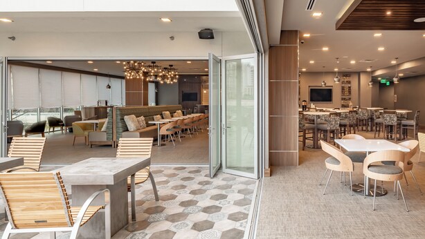 A modern interior with a dining area, seating arrangements, and a bar. - Element by Marriott Dallas Downtown East (Dallas)