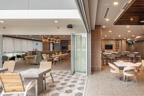 A modern interior with a dining area, seating arrangements, and a bar. - Element by Marriott Dallas Downtown East (Dallas)