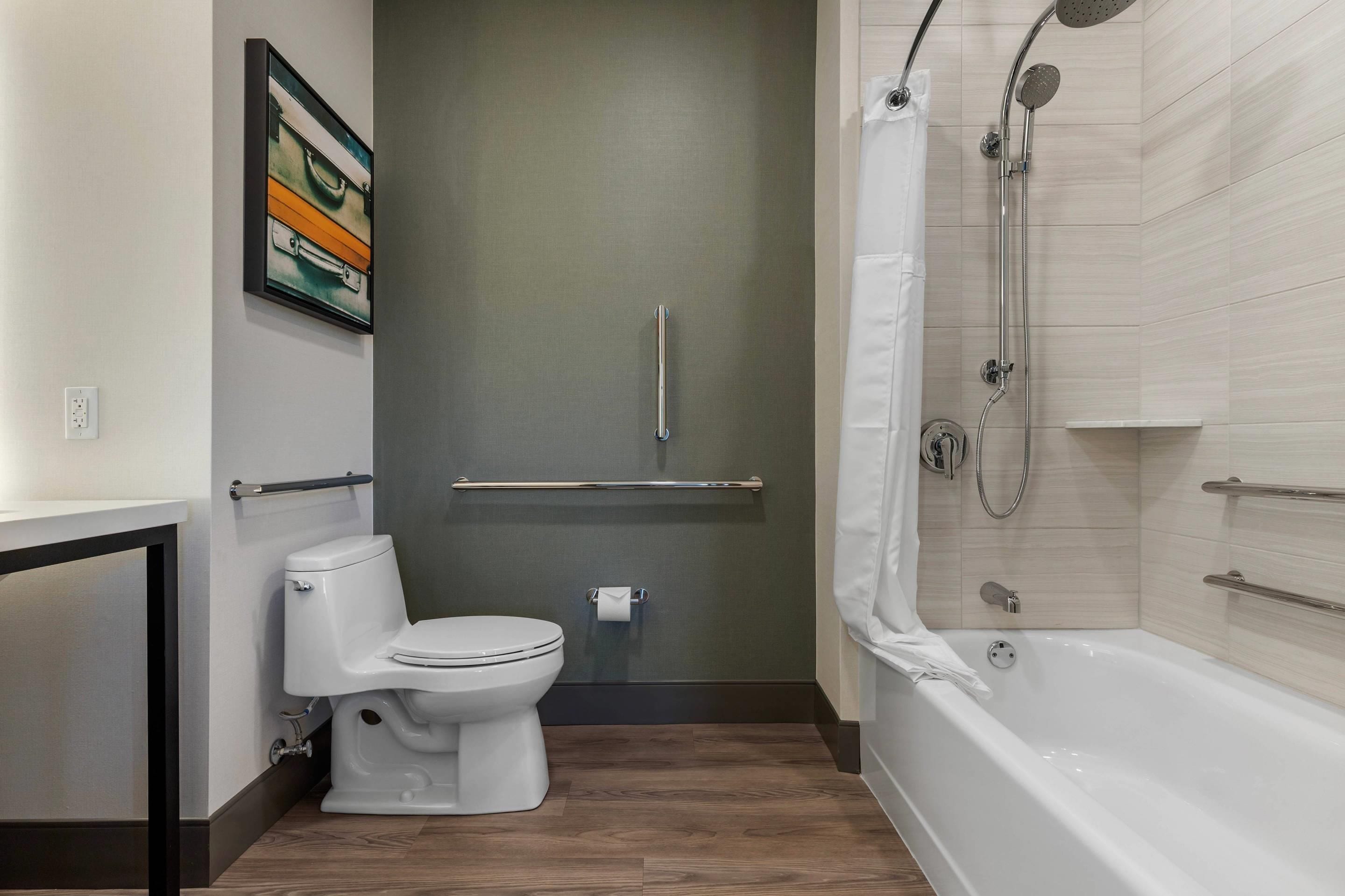 Un baño moderno con inodoro, ducha con puerta de cristal y toallero.