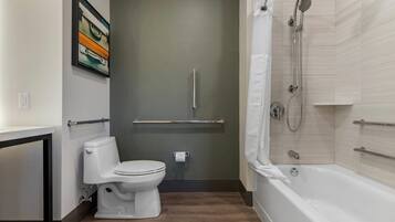 Un baño moderno con inodoro, ducha con puerta de cristal y toallero.