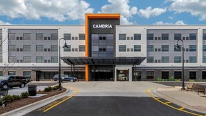 A modern building with a prominent CAMBRIA sign, a covered entrance, and a parking area with yellow lines. - Cambria Hotel Arundel Mills - BWI Airport (Hanover)