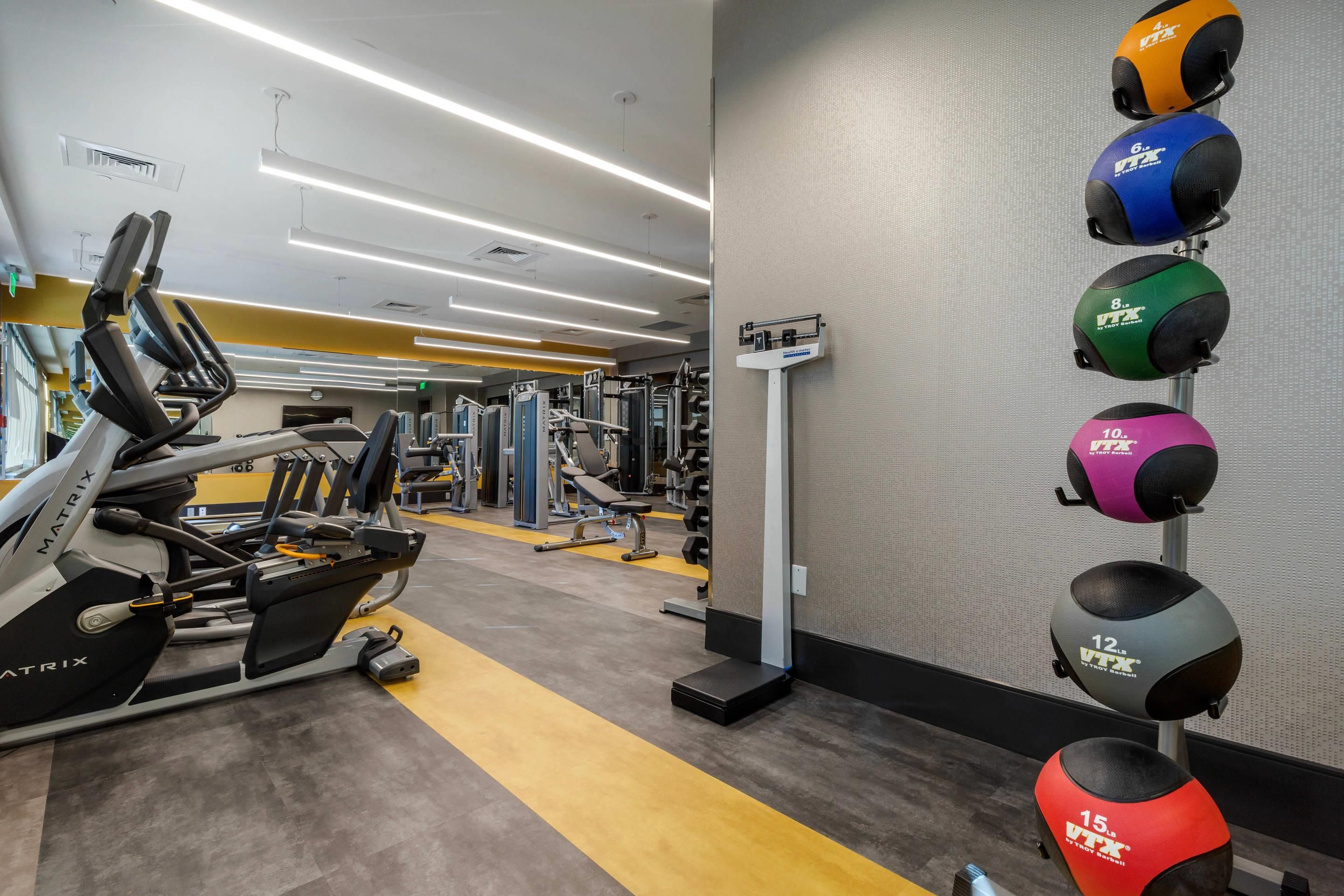 A gym with various exercise equipment, including treadmills and weight machines.