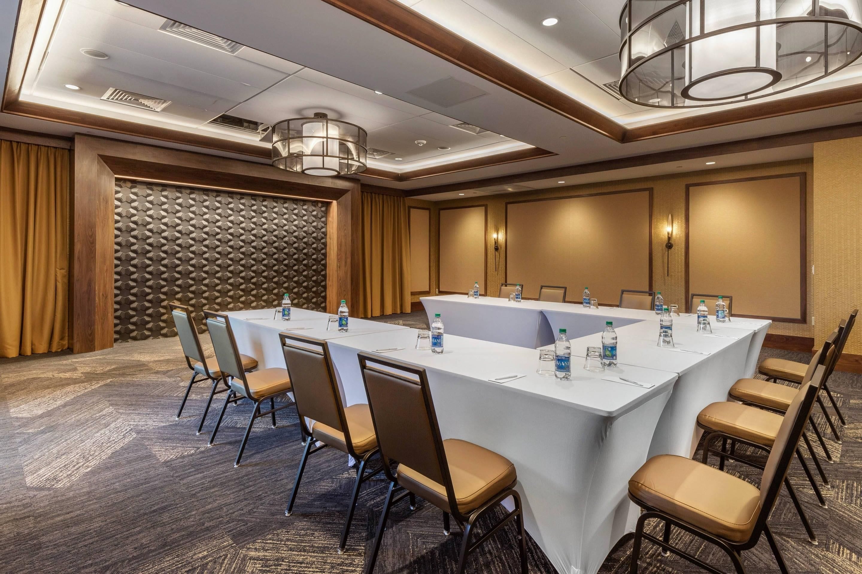 A conference room with a long table, chairs, and water bottles.