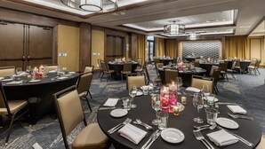 A hotel conference room with round tables set for dining, equipped with chairs, tables, and centerpieces. - Cambria Hotel Arundel Mills - BWI Airport (Hanover)