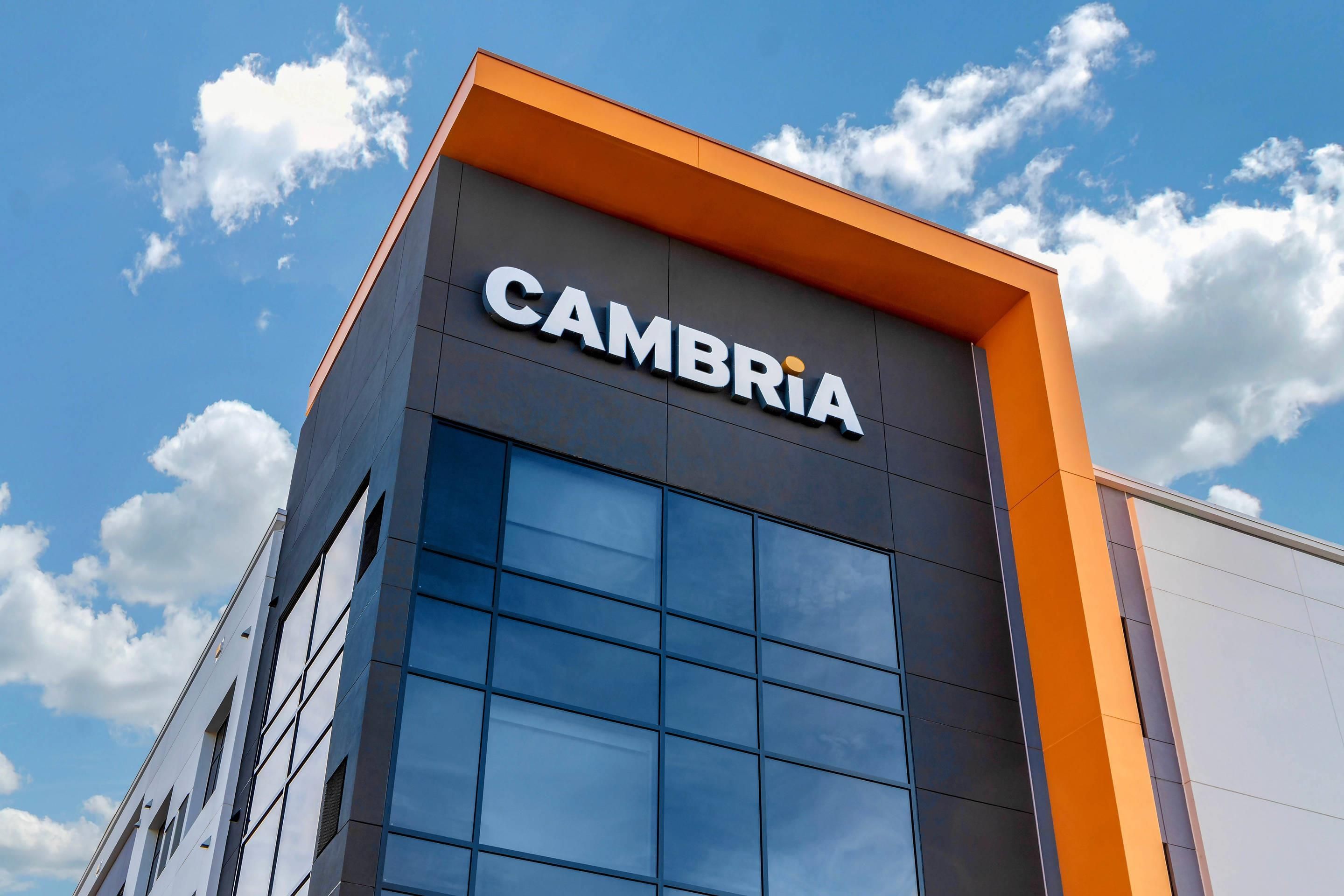 Un edificio moderno con el letrero 'CAMBRIA' bien visible en la fachada.