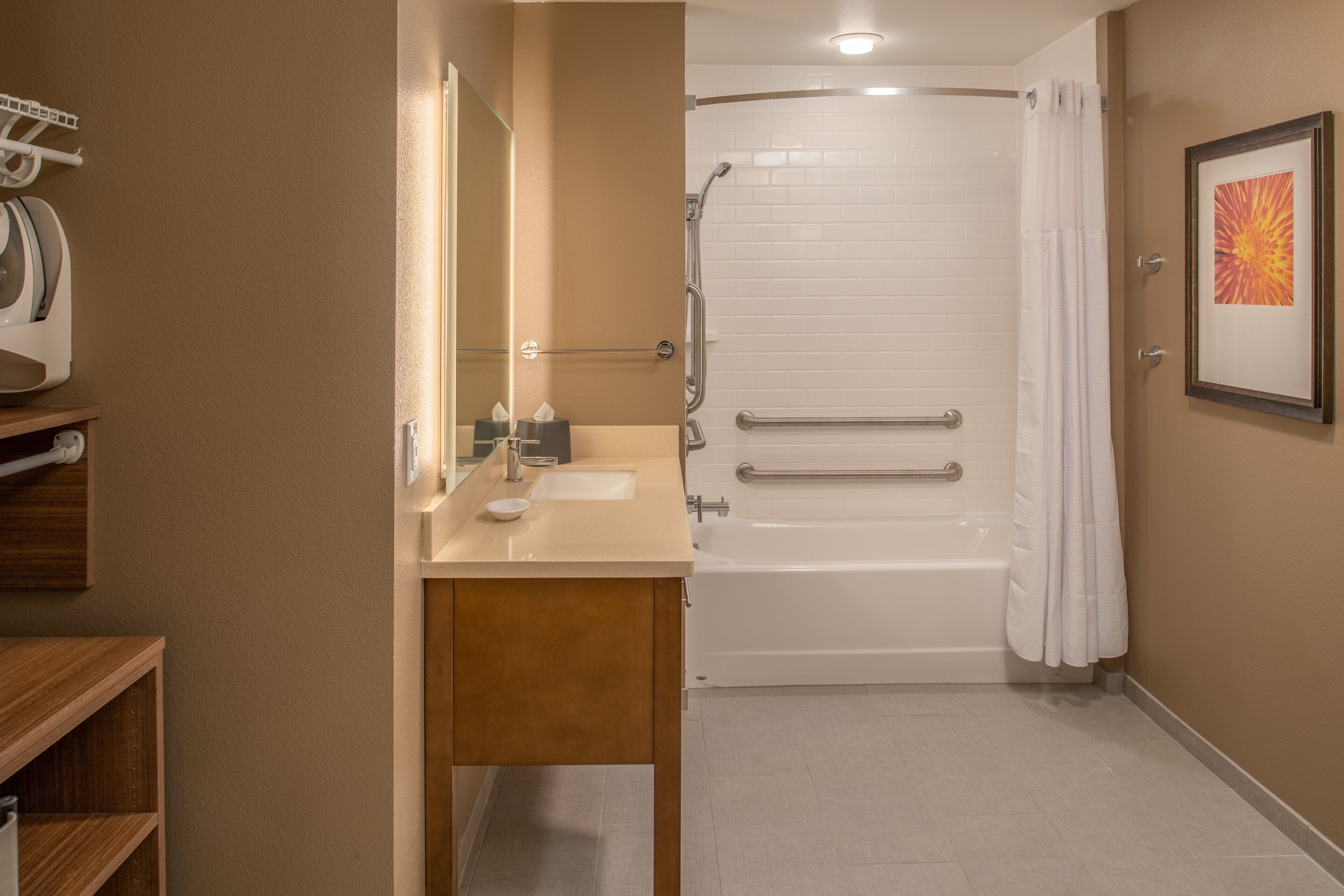 A bathroom with a sink, mirror, and bathtub.