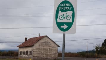 A sign for a scenic bikeway with a rustic wooden building in the background.