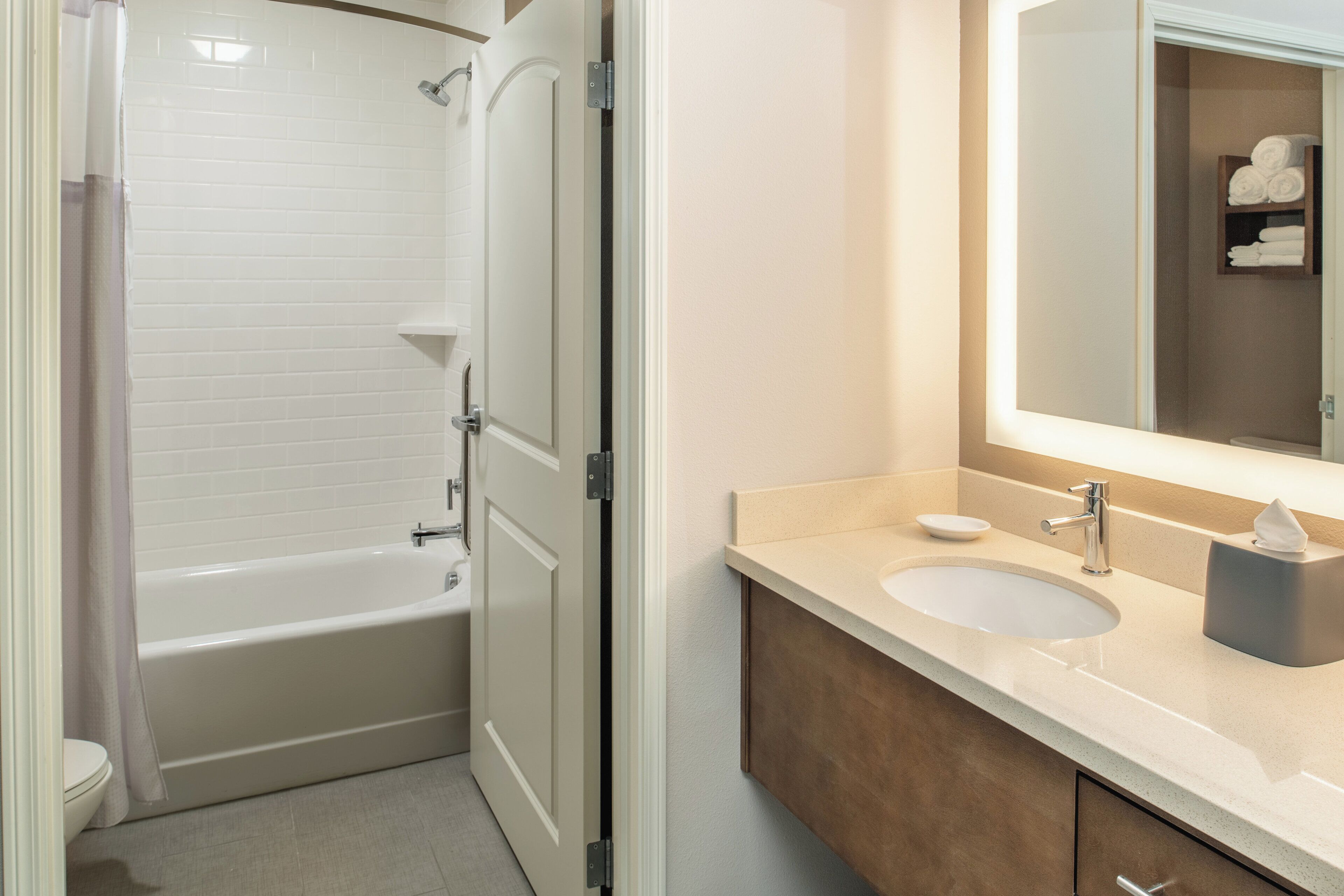 A bathroom with a bathtub, toilet, sink, and a mirror.