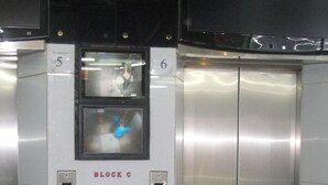 A modern elevator with digital displays, a water dispenser, and a metallic interior. - Philippine Hostel (Kowloon)