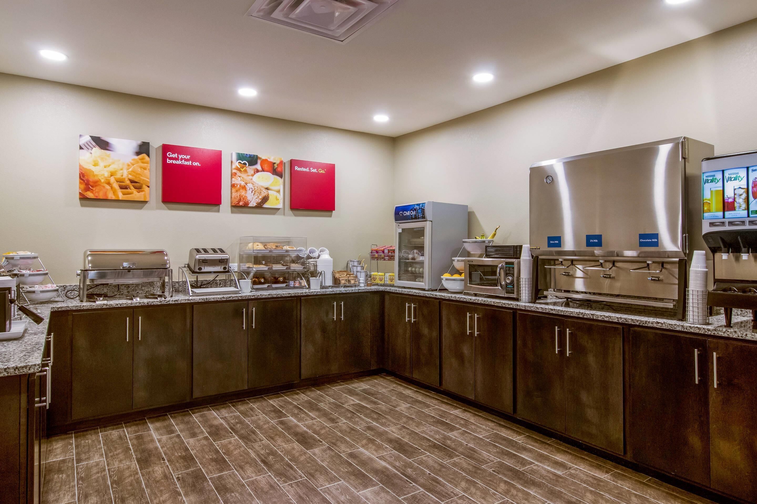 A breakfast bar with various food items and appliances.