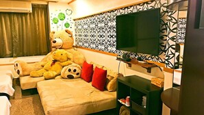 A cozy hotel room with a large bed, a sofa, and a TV. - Star B&B (Tainan)