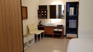 A compact hotel room with a bed, a desk with a chair, a small kitchenette, and a wardrobe. - Tainan Yi Zhan (Tainan)