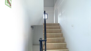 Una escalera con barandilla y un interruptor de luz en la pared.