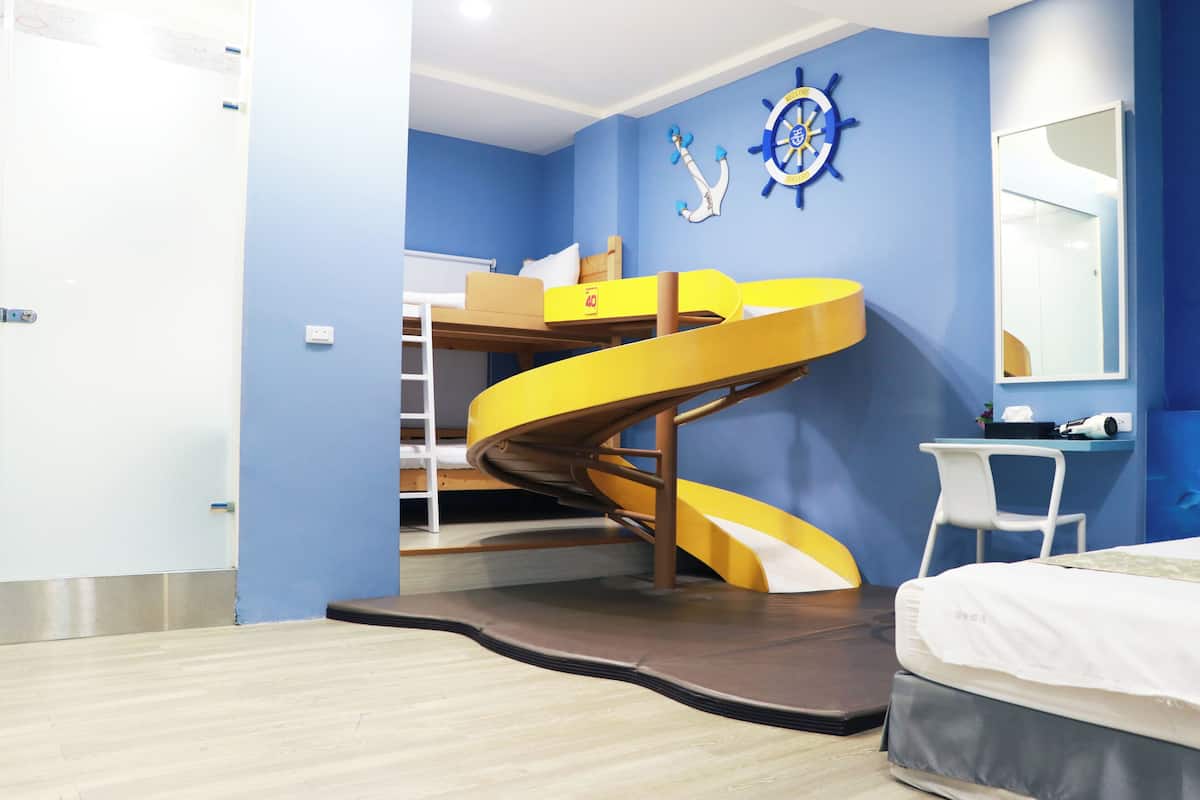 A room with a spiral staircase, a bunk bed, a desk, and a mirror.