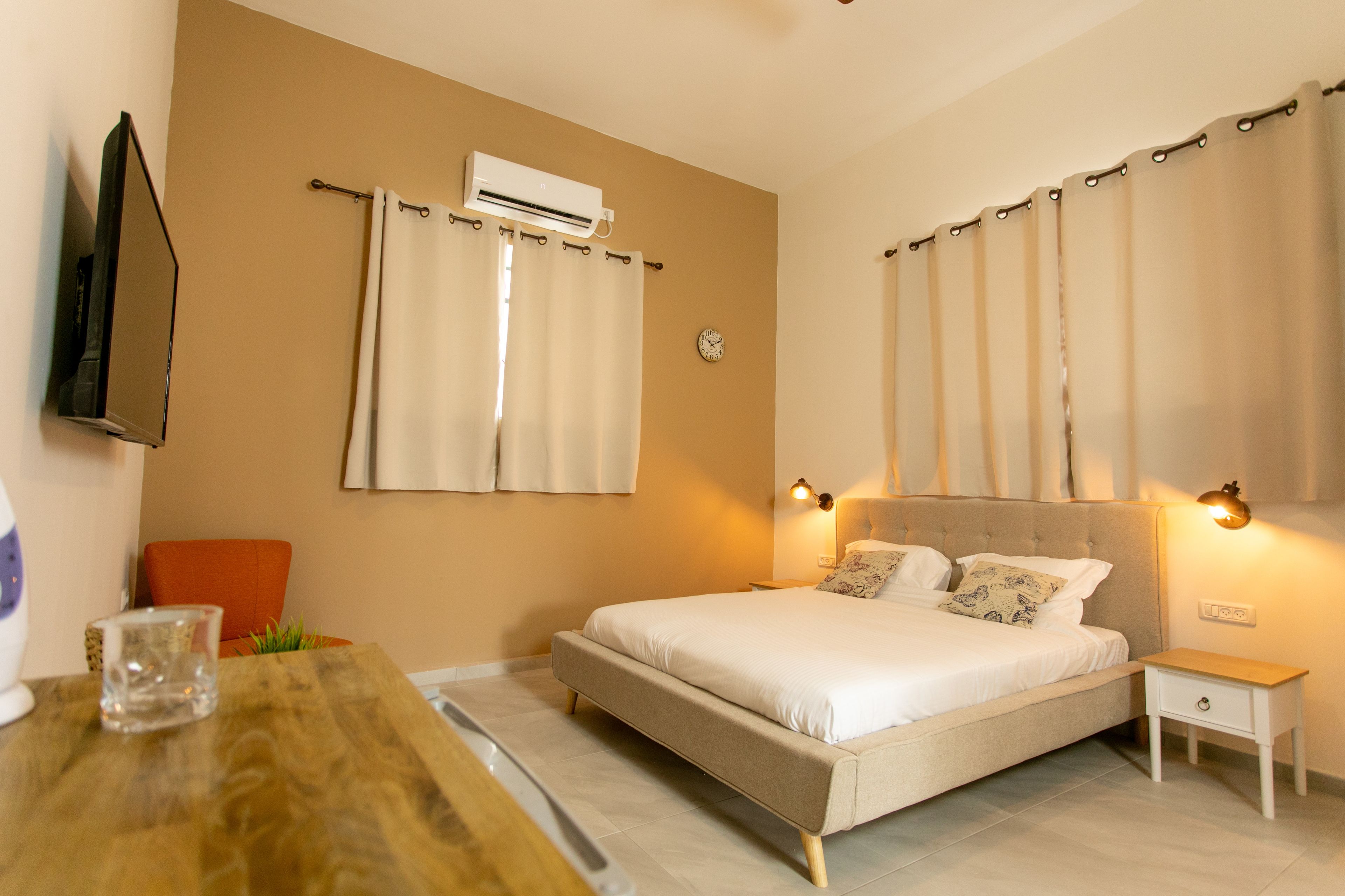 Un dormitorio con cama, mesita de noche y equipo de aire acondicionado.