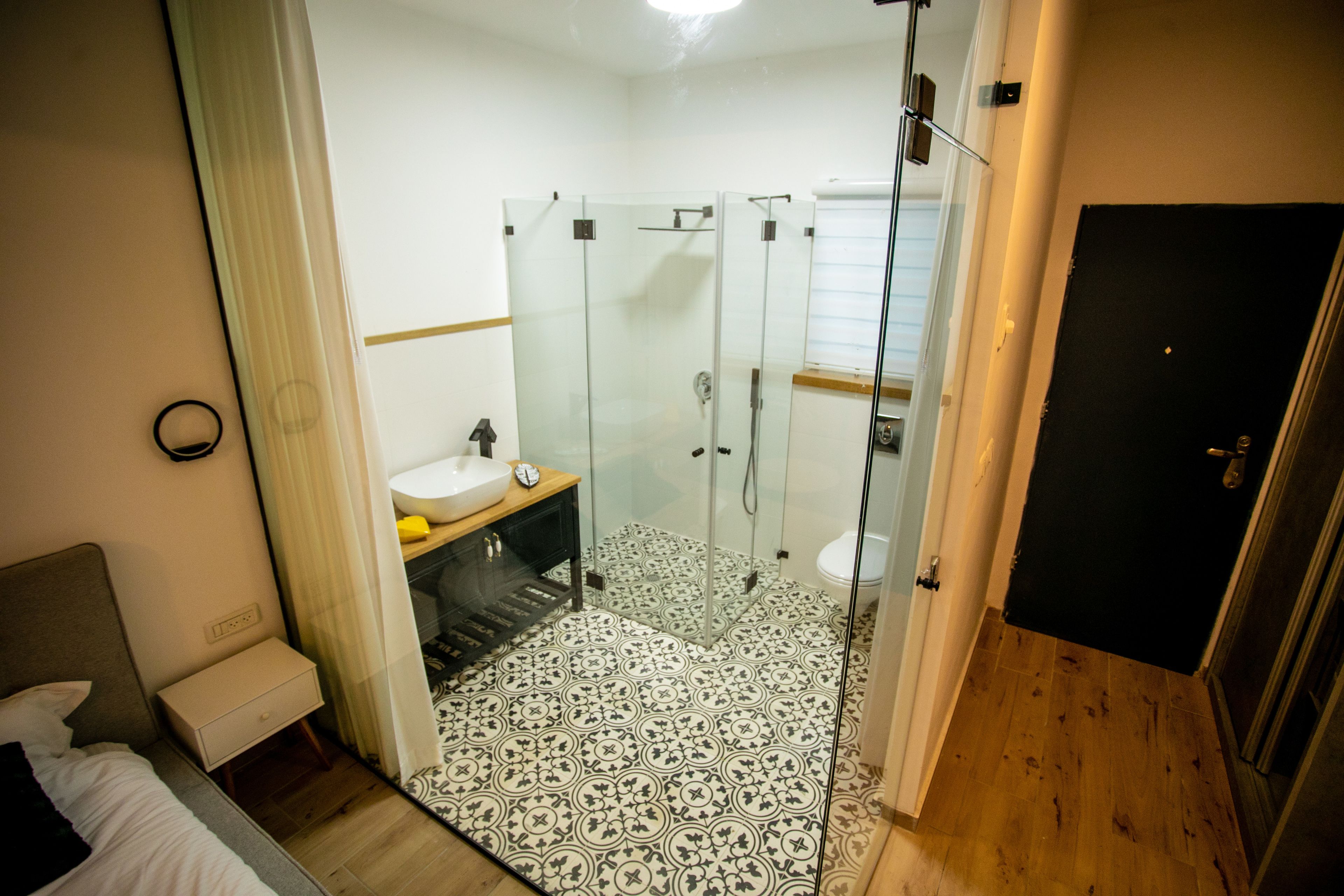 Un baño de hotel con ducha de vidrio, lavamanos y retrete.