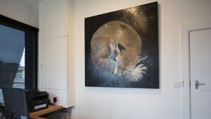 Een receptiebalie met een computer, printer en een schilderij van een vos aan de muur.