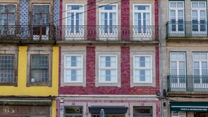 A row of colorful buildings with multiple stories, featuring balconies and windows. - Stylish Studio in lively City Center (Oporto)