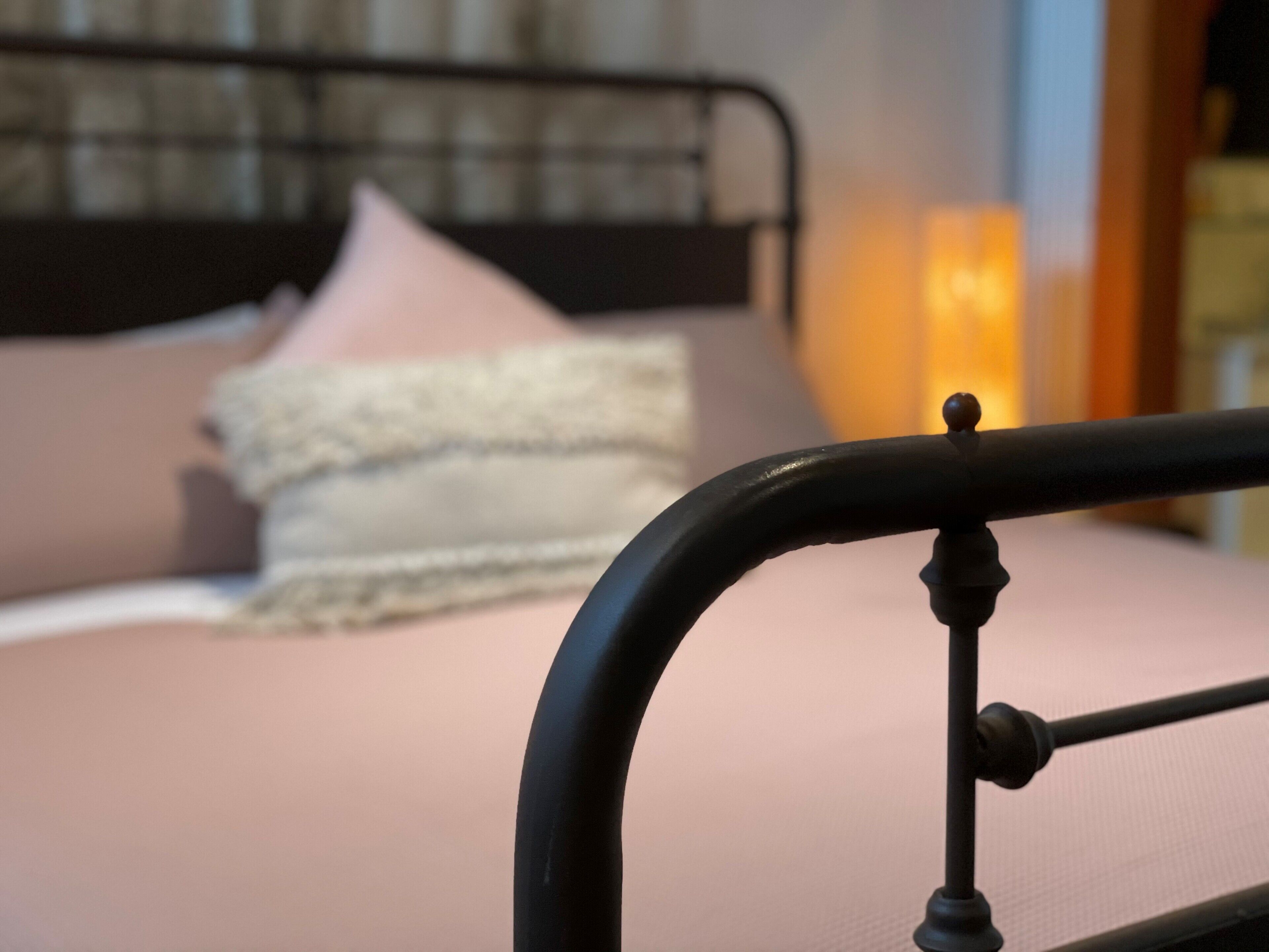 Un lit avec une tête de lit, des oreillers et une couverture.