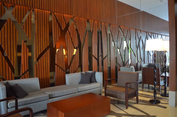 A modern lobby with a sofa, chairs, and a coffee table.