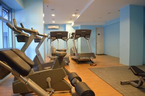 A gym with stationary bikes, treadmills, and weight machines.