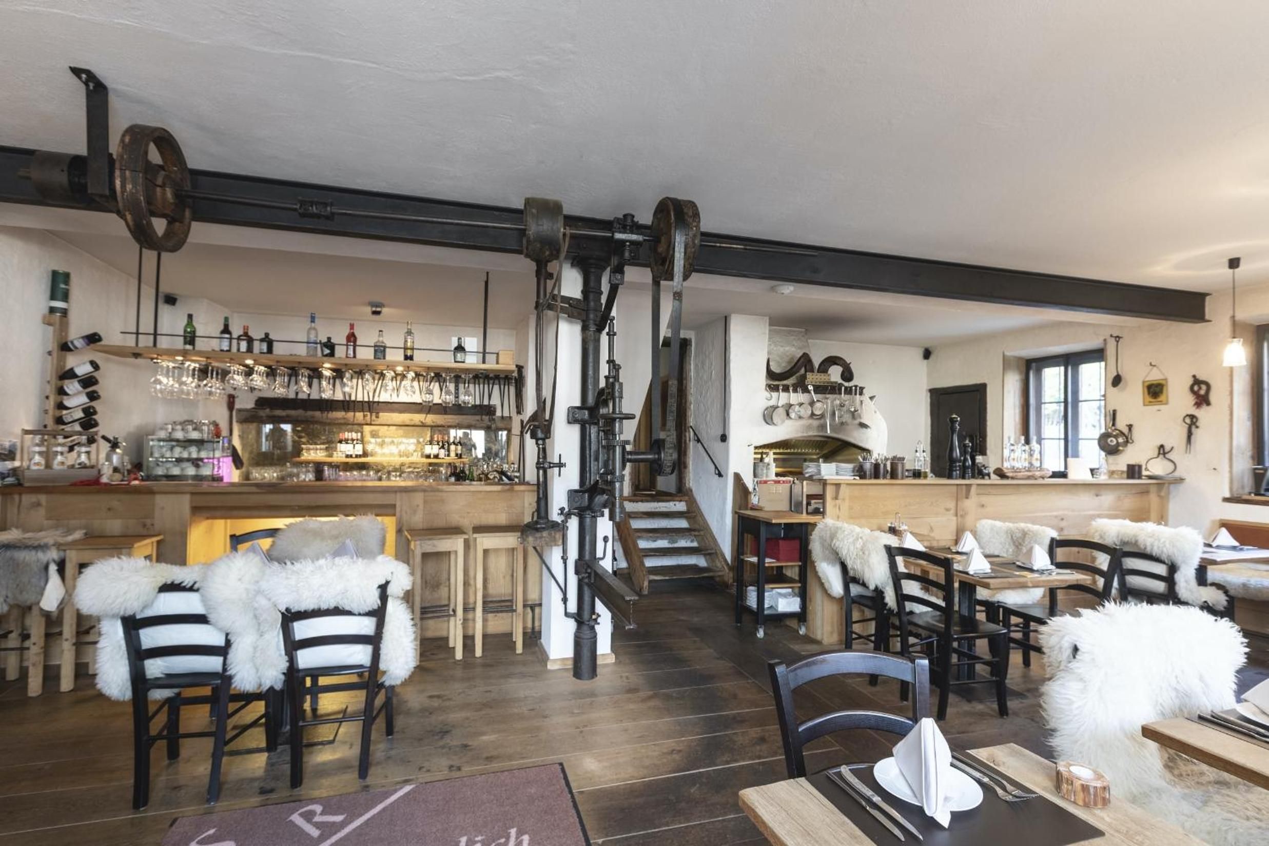Ein rustikaler Innenraum mit Holzwandlungen, einer Bar und einer Treppe.