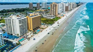 A coastal cityscape with a beachfront, high-rise hotels, and a clear view of the ocean. - Sand Dollar Breathtaking Direct Oceanfront Views, New Pool and Beach Access Open (Daytona Beach Shores)