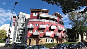 A multi-story residential building with balconies, a garage, and a parking area. - Design Apartment Catch Me If You Can (Freiburg im Breisgau)